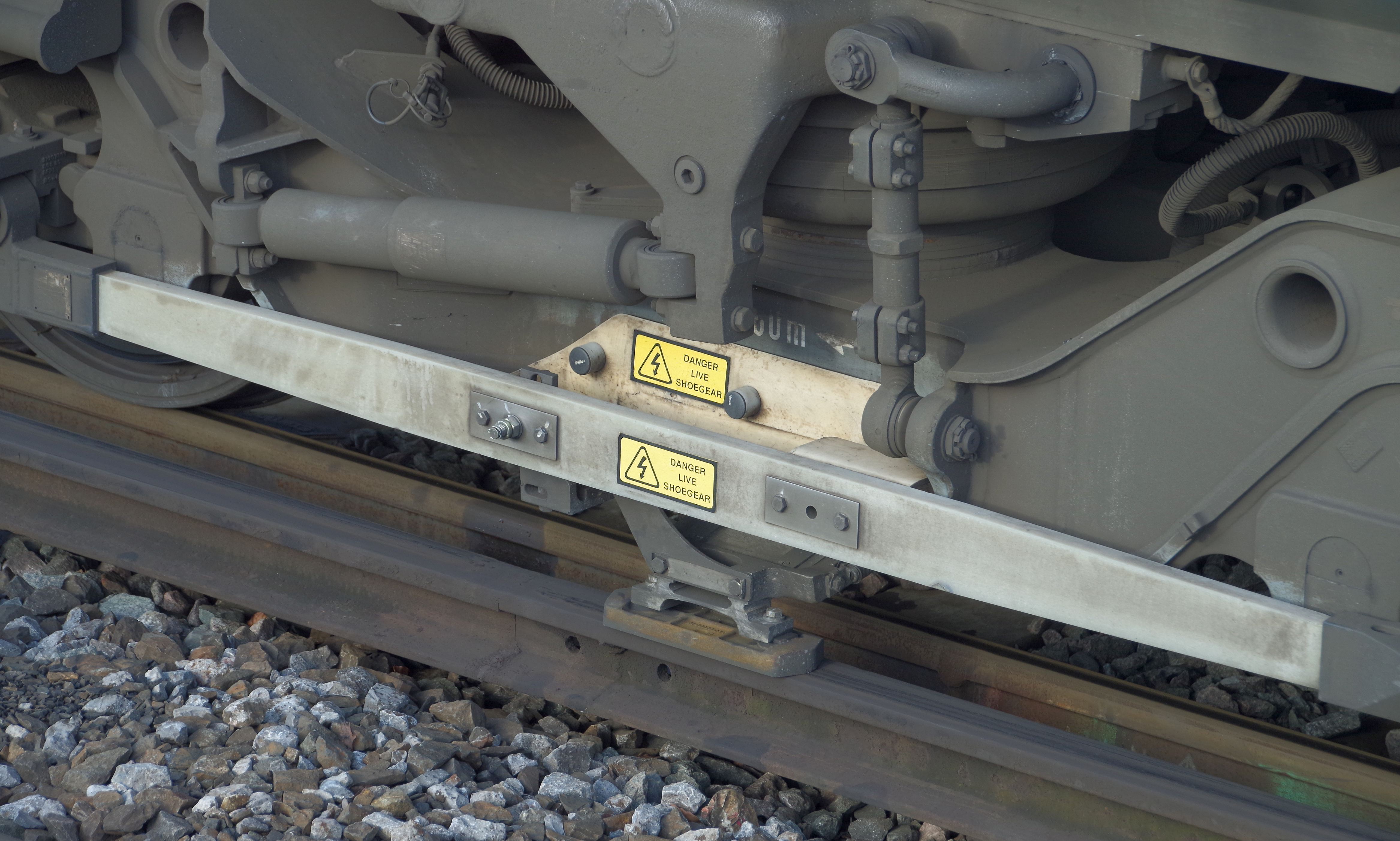 Close-up of third-rail conductor rail and train shoegear pickup equipment